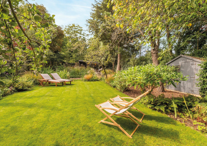 Nestled beneath mature trees lies a secluded lawn