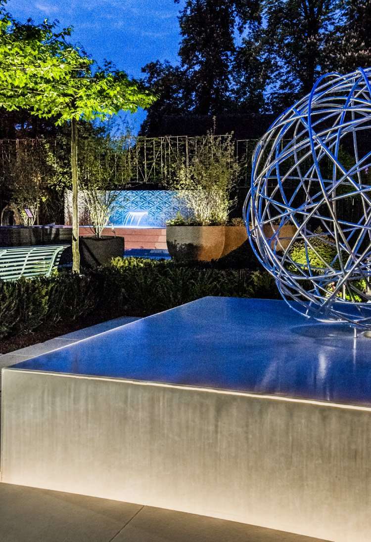 Luxury spa garden at night with dramatic water features designed by Ann-Marie Powell Gardens