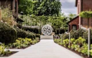 Garden sculpture with yew topiary in luxury hotel garden designed by Ann-Marie Powell